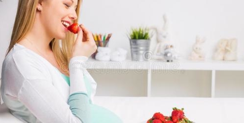Pregnant woman eating strawberries