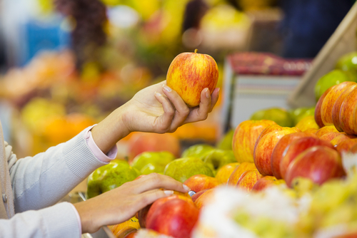 Woman,Buys,Fruits,And,Vegetables,At,A,Market,,Apple