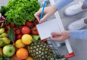 Woman,Pushing,A,Shopping,Cart,Full,Of,Fresh,Greens,And